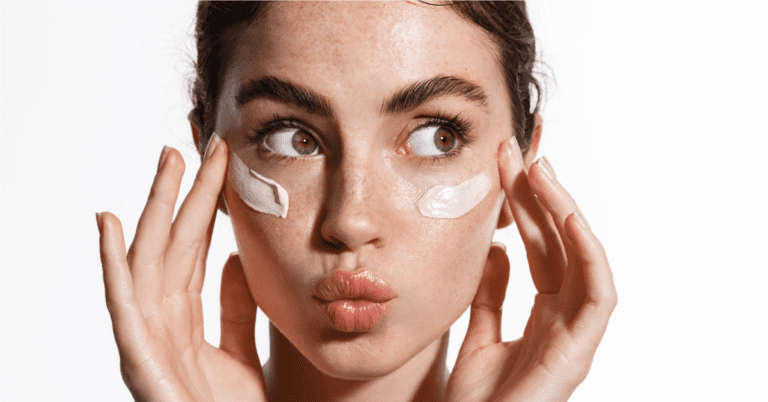 Rostro de mujer sonriente se aplica Crema humectante Fisiogel y luego se aplica protector solar Umbrella, la combinación perfecta para el cuidado de la piel.